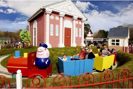 A picture of Grandpa Pig's Little Train Ride. A train ride with Grandpa Pig at the front with a family in the carriages.